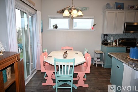 A kitchen with a table and chairs.
