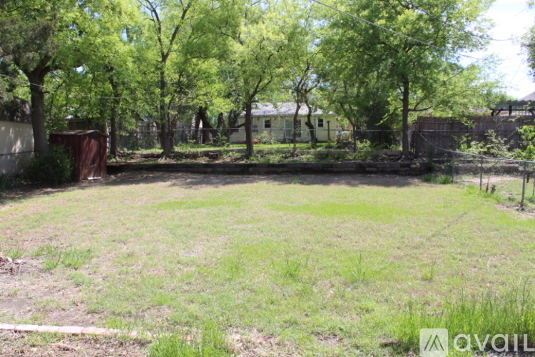 A backyard with a fence and trees.