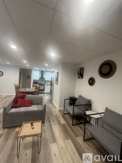 A living room with a grey couch, a wooden coffee table, and a black chair.