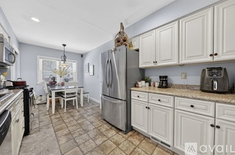 A kitchen with a refrigerator, oven, and sink.