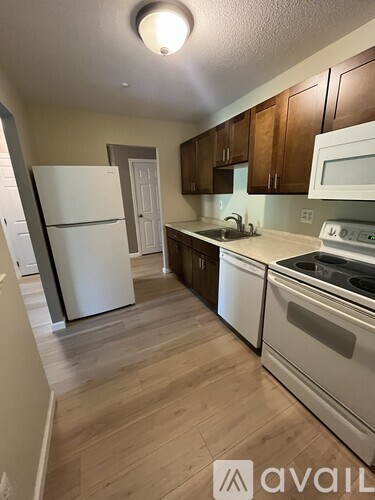 A kitchen with a white fridge and stove top oven.
