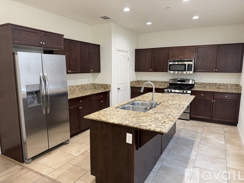 A kitchen with brown cabinets and a granite countertop.