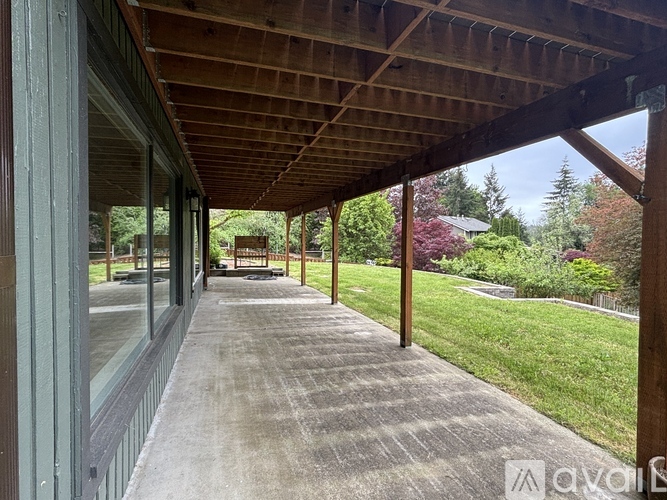 A wooden covered walkway leads to a grassy area.
