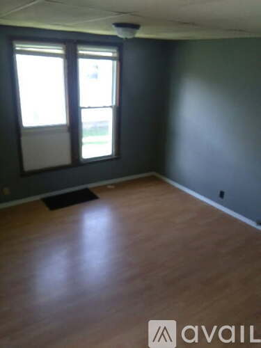 A room with wooden flooring and a window.