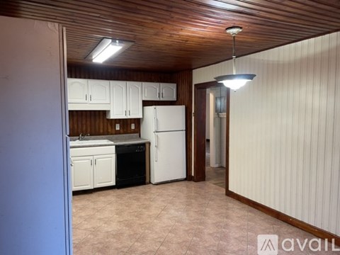 A kitchen with white appliances and wooden cabinets.