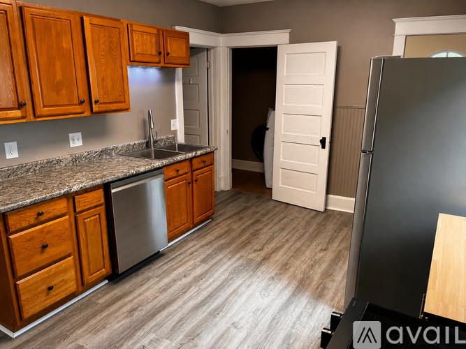 A kitchen with wooden cabinets and a granite countertop.