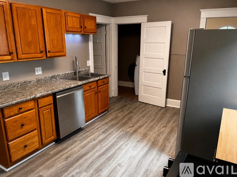 A kitchen with wooden cabinets and a granite countertop.