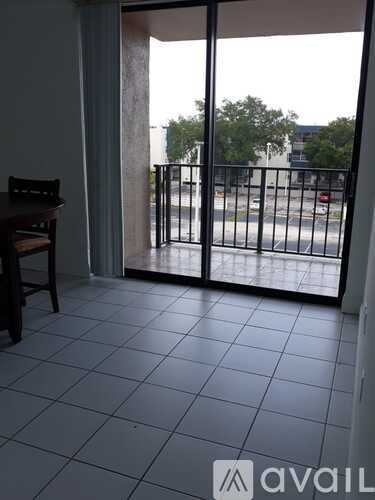 A balcony with a chair and a view of the street.