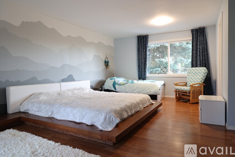 A bedroom with a large bed and a mountain mural on the wall.
