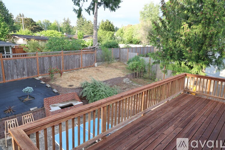 A backyard with a wooden deck and a small pool.