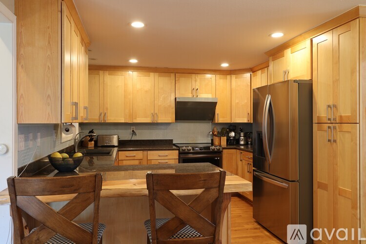 A kitchen with wooden cabinets and a black countertop.