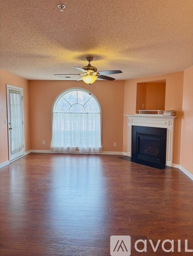 A room with a fireplace and a ceiling fan.