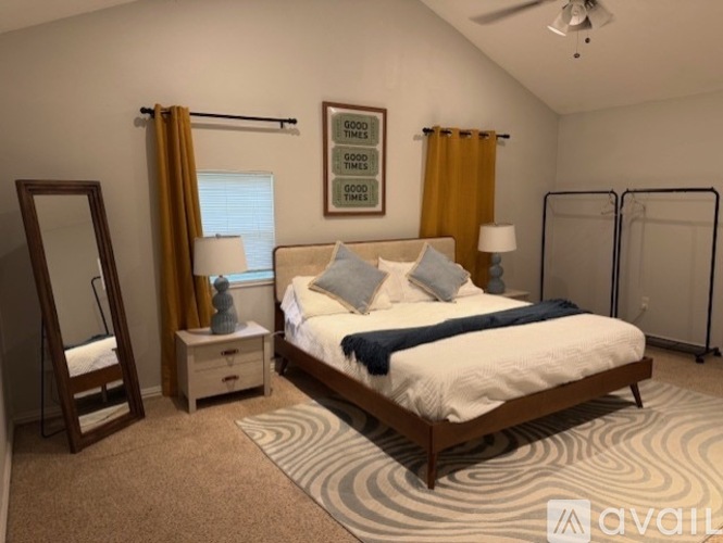 A bedroom with a bed, nightstand, and a dresser with a mirror.