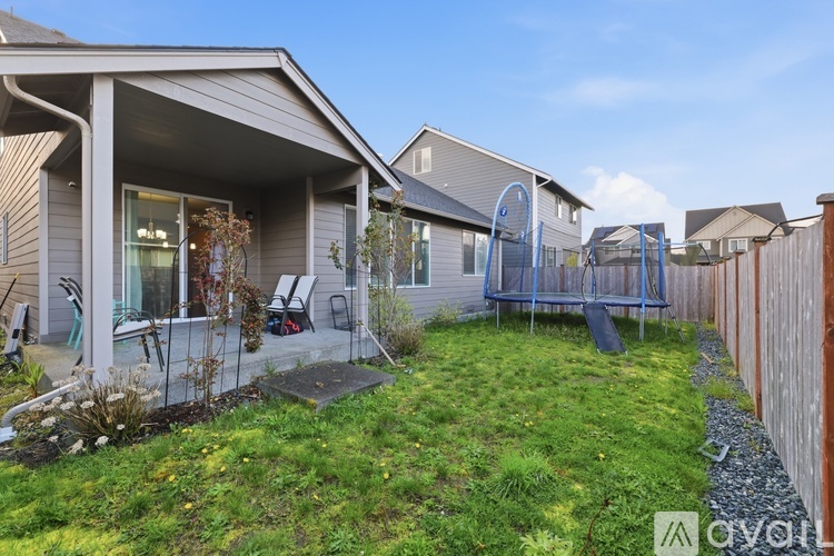 A backyard with a wooden fence and a playground.