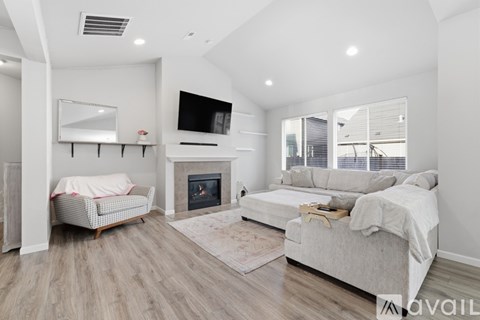 A modern living room with a fireplace and a television mounted above it.