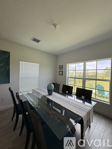 A dining room with a table and chairs.