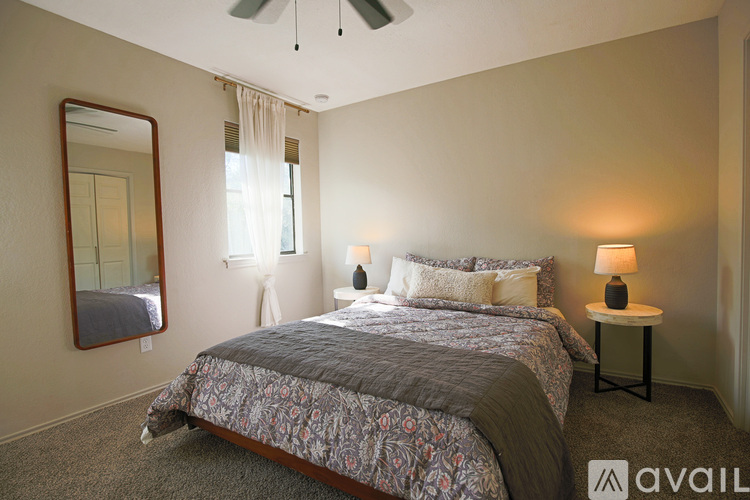A bedroom with a large bed and a ceiling fan.