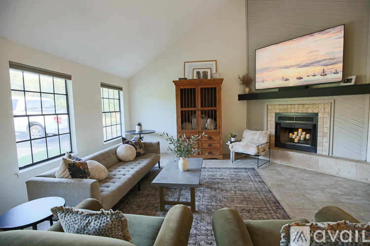 A living room with a fireplace and a television on the wall.