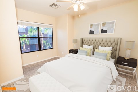A bedroom with a large bed and a ceiling fan.