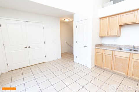 A kitchen with white cabinets and a tiled floor.