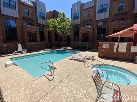 A pool surrounded by buildings and trees.