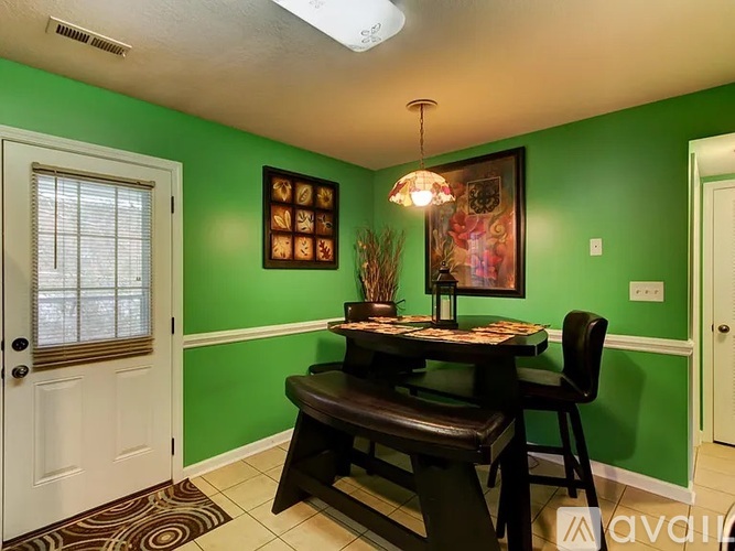 A dining room with a table and chairs.