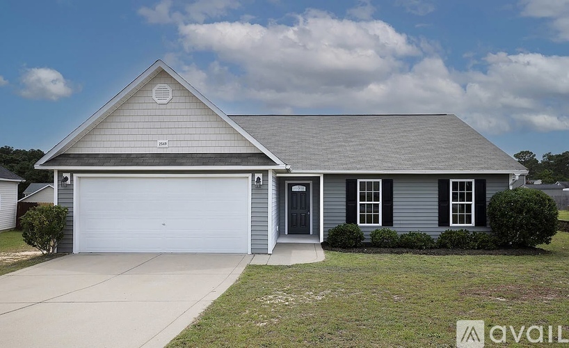 A house with a grey roof and a white garage door.