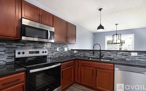 A kitchen with wooden cabinets and a black countertop.