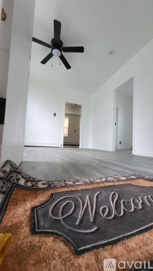 A room with a rug that says "Welcome" on it.