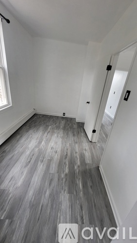 A room with a wooden floor and white walls.