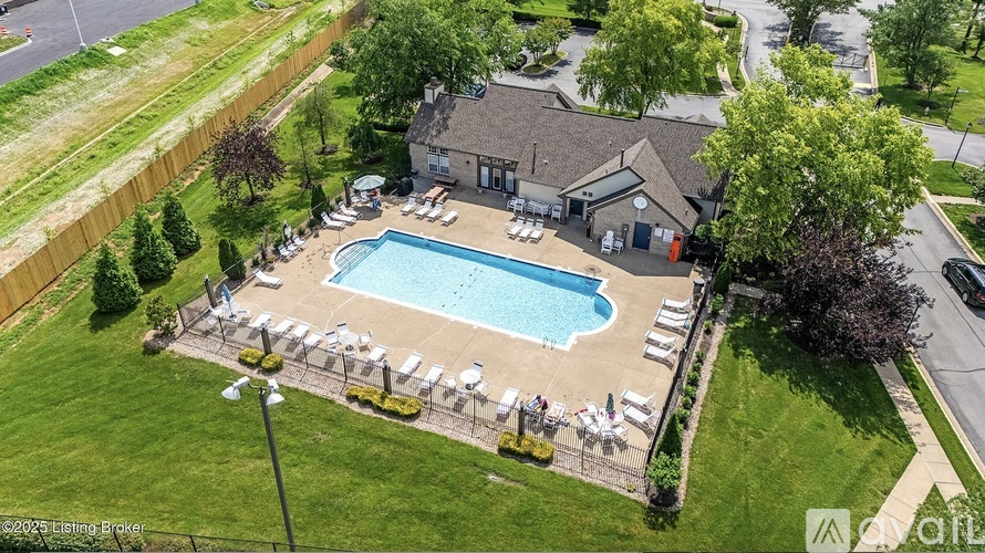 An aerial view of a pool with lounge chairs and a building in the background.