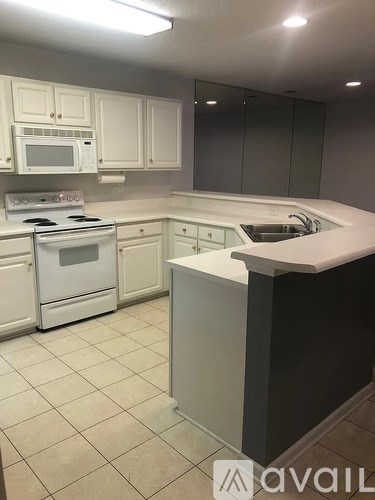 A kitchen with white cabinets and appliances.