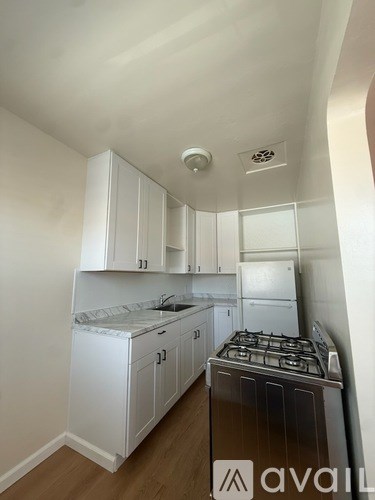 A kitchen with white cabinets and a stove top oven.