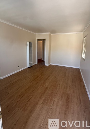A room with wooden flooring and white walls.