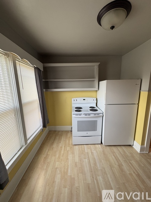 A kitchen with a white stove and refrigerator.