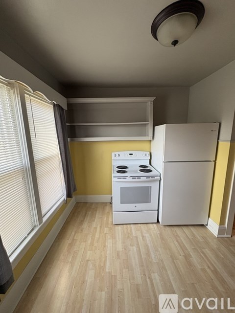 A kitchen with a white stove and refrigerator.