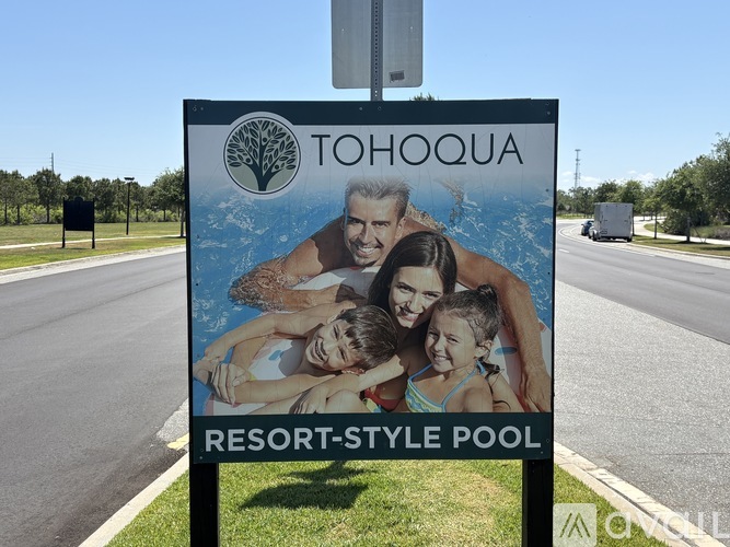 A sign for Tohoqua Resort-Style Pool featuring a family.