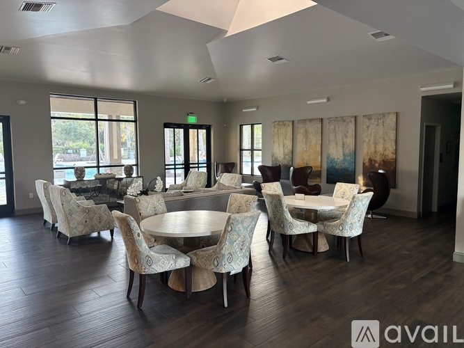 A dining room with a round table surrounded by chairs.