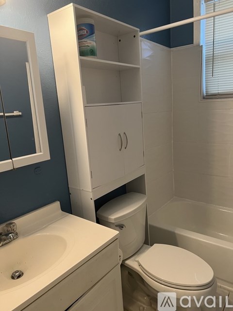 A white bathroom with a sink, toilet and medicine cabinet.
