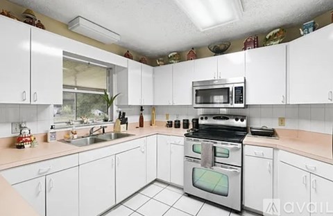 A kitchen with white cabinets and appliances.