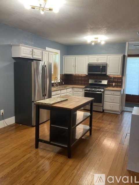 A kitchen with a wooden table and a refrigerator.