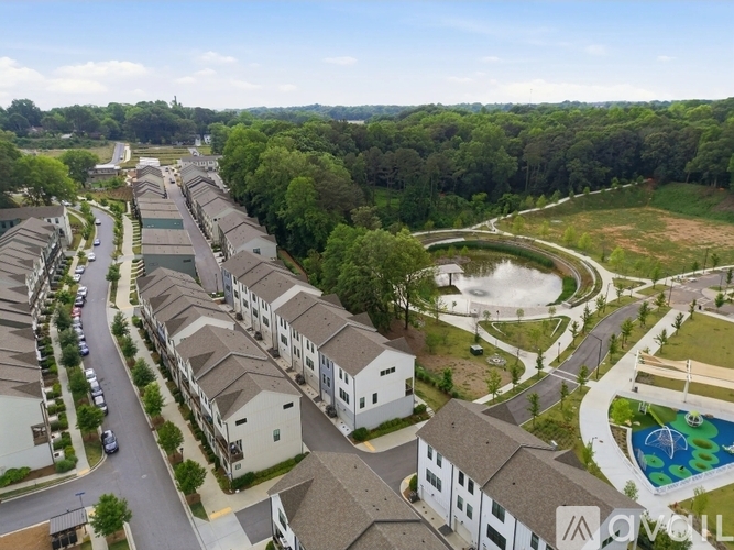 A bird's eye view of a residential area with houses, a pool, and a road.