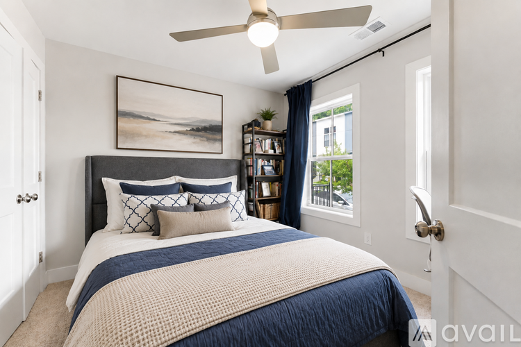 A bedroom with a large bed and a ceiling fan.