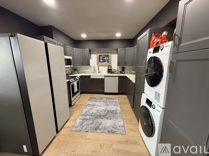 A modern kitchen with a refrigerator, oven, and washing machine.