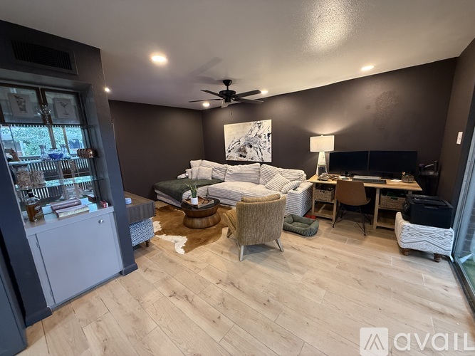 A well-lit bedroom with a large bed and a desk with a chair.