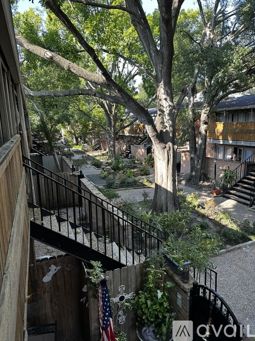 A balcony with a railing and a tree in front of a building.