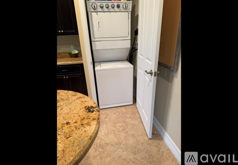 A white dishwasher is in a kitchen next to a white door.