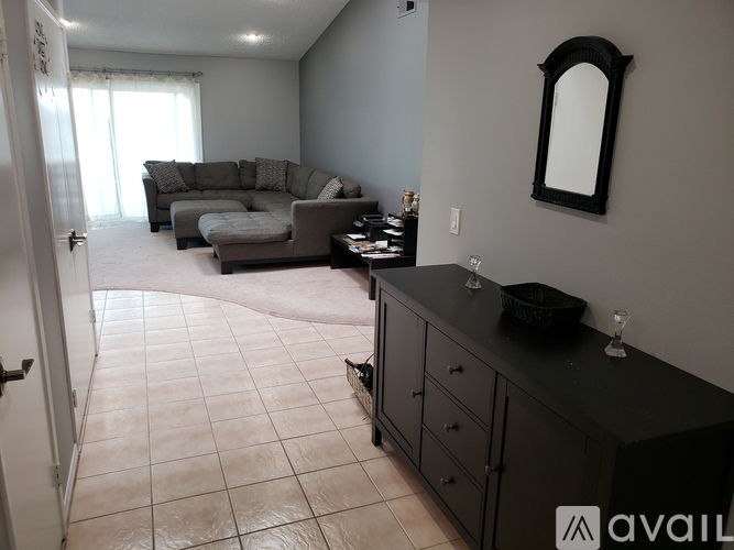A living room with a grey couch and a black countertop.
