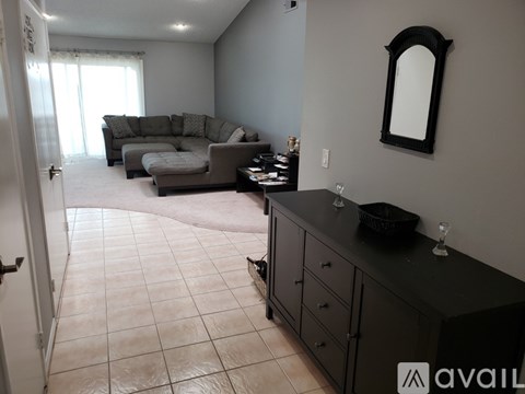 A living room with a grey couch and a black countertop.