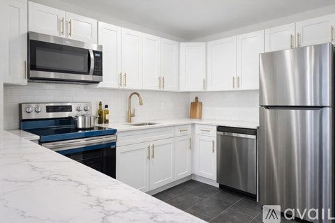 A kitchen with white cabinets and a marble countertop.
